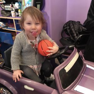 A toddler with SMDS holds a basketball