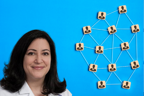 Dr. Shalhub is wearing a white coat and standing in front of an abstract representation of a network of different people.